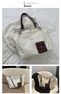 Detail view of large white canvas tote bag with brown leather straps and front pocket
