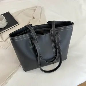 Détail du sac cabas noir montrant les surpiqûres blanches et la texture du similicuir