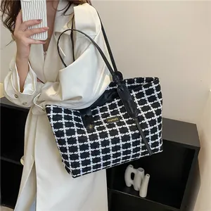 Grand sac cabas en tweed à carreaux noir et blanc avec anses en cuir sur mannequin