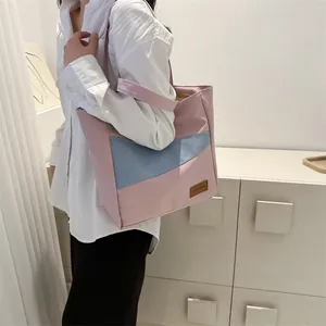 Detailansicht der pink-blauen Oxford-Tragetasche im Color-Blocking-Design am Modell
