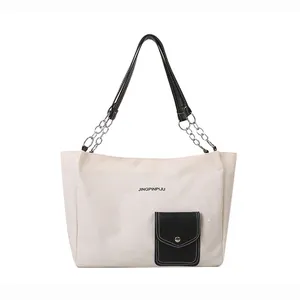 White canvas tote bag with black leather straps and silver chains for women commuting