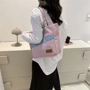 Detailaufnahme der rosa-blauen Canvas-Tasche mit Fokus auf das modische Leder-Etikett