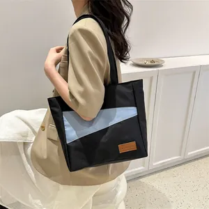 Detailaufnahme der Canvas-Einkaufstasche mit schwarz-blauem Patchwork-Design und Lederetikett