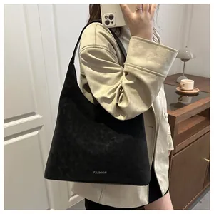 Dettaglio della borsa tote in finta pelle scamosciata nera con scritta FASHION