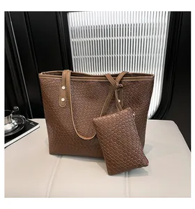 Close-up of brown woven tote bag set with metal rivets and matching pouch details