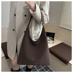 Dettaglio della grande borsa tote marrone opaca con testo fashion e tracolla larga