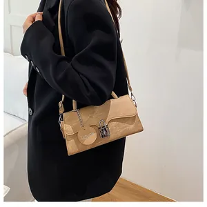 Detail of khaki retro small square bag with silver clasp and fashion metal charm