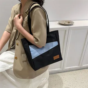 Minimalistische Canvas-Einkaufstasche im schwarz-hellblauen Farbblock-Design mit Lederetikett