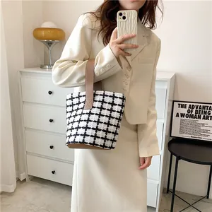 Chic black and white tweed tote bag with brown leather handles for a professional look