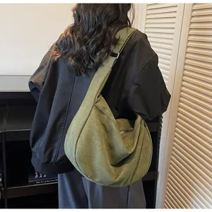 Detail of adjustable strap and zipper on army green canvas crescent crossbody bag