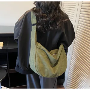 Detailed back view of a grass green oversized suede crescent crossbody bag