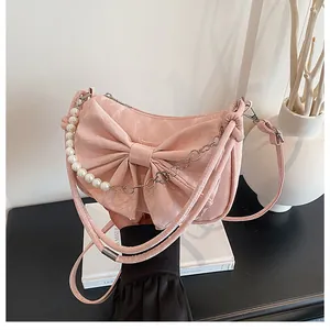 Detail of pink bow handbag featuring marble texture, pearl chain and metal accents