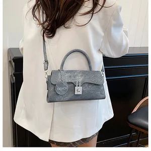Detail of blue-grey vintage denim texture bag with silver buckle and fashion charm tag