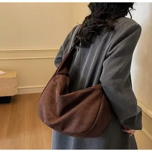 Detail of the oversized brown suede tote bag showing soft texture and slouchy design