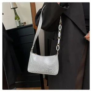 Vue détaillée du motif peau de serpent élégant sur un sac blanc à bandoulière chaîne