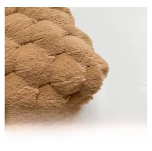 Dettaglio macro della borsa a tracolla marrone in peluche con trama trapuntata a rombi