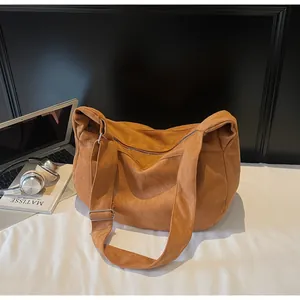 Macro shot of brown suede hobo bag with zipper closure and adjustable silver buckle