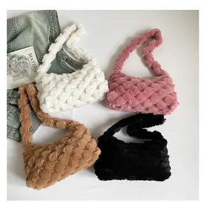 Dettaglio borse a tracolla in peluche intrecciato nei colori bianco, rosa, cammello e nero