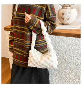 Dettaglio della trama in peluche bianco e cerniera di questa morbida borsa invernale
