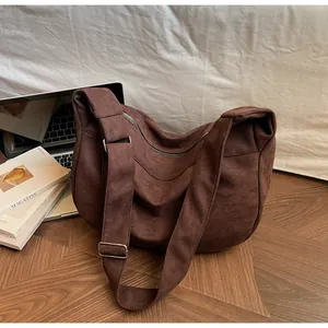 Detailed view of the large capacity dark brown canvas crescent bag on a desk