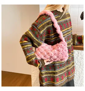 Dettaglio della borsa a tracolla intrecciata in peluche rosa con morbida texture
