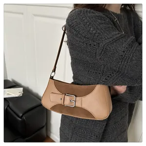 Vista detallada de bolso de hombro en cuero patchwork marrón con hebilla metálica en una modelo