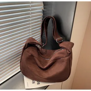 Detail of adjustable silver buckle on brown suede crescent crossbody tote bag