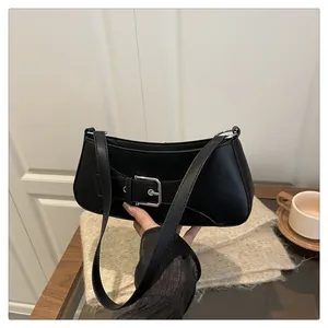 Detalle del elegante bolso baguette negro con una gran hebilla decorativa de metal