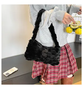 Dettaglio della borsa tote in ecopelliccia nera con texture intrecciata e morbida