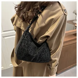 Detail of the leopard print hobo bag texture paired with a classic khaki trench coat