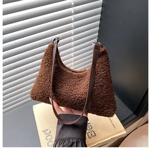 Detail of soft brown faux shearling tote with dark leather handles and metal hardware