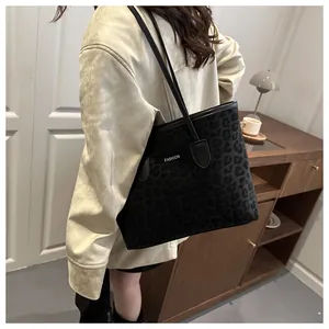 Détail du sac cabas noir avec texture léopard et logo FASHION porté par un mannequin