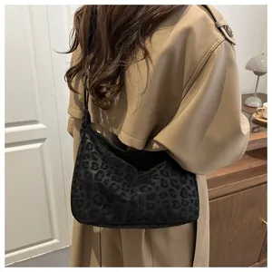 Detail of black leopard print hobo bag worn with a classic autumn trench coat