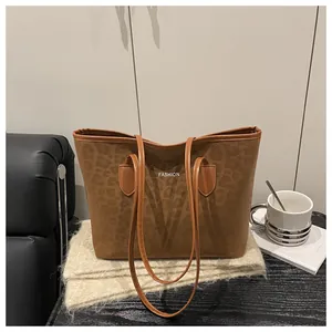 Gros plan d'un sac cabas marron à motif léopard avec texte fashion sur surface textile