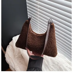 Close-up of brown plush faux fur tote bag with slim shoulder strap and zipper detail