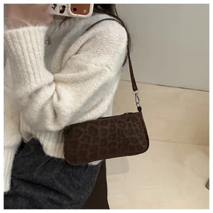 Close-up of leopard print baguette bag with soft suede texture and silver hardware details
