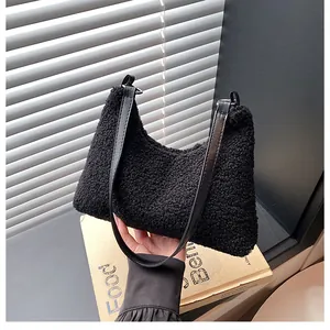 Close-up of black fleece tote bag showing soft fluffy texture and leather shoulder strap