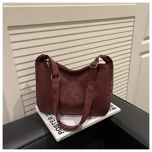 Close-up of dark red tote bag with leopard emboss texture and golden hardware details