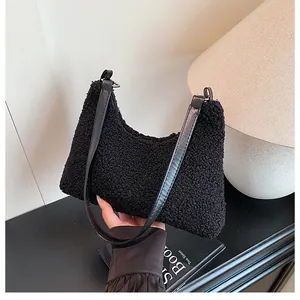 Detailed texture of black plush fleece shoulder bag with premium leather handle
