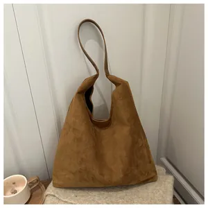 Καφέ σουέτ τσάντα tote σε φθινοπωρινό σκηνικό με φλιτζάνι καφέ και απαλά υφάσματα
