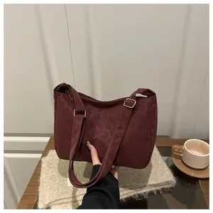 Close-up of burgundy leopard jacquard tote with adjustable strap and gold hardware