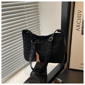 Detailed close-up of large leopard print tote bag with gold metal adjustment buckles