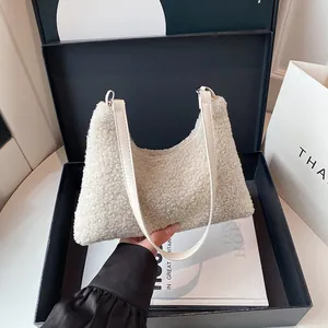 Winter faux shearling tote bag in cream white held by a model over a gift box background