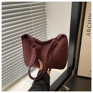 Detail of burgundy tote bag with adjustable strap and premium zipper hardware