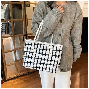 Detail of black and white striped tote bag with white strap on a lifestyle background