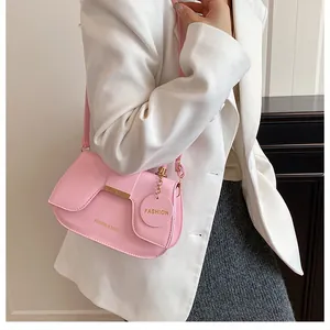 Détail du sac selle rose avec garniture en métal doré et lettrage Fashion & Bags