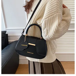 Sac selle noir tendance avec détails dorés et bandoulière réglable porté par un mannequin