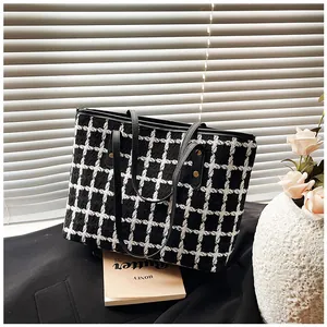 Detail shot of black and white striped tweed tote bag with premium leather straps