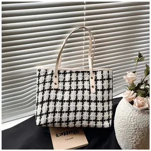 Macro detail of black and white striped tweed tote bag with cream handles and texture