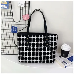 Detail of black and white striped tweed tote bag with gold studs and leather straps